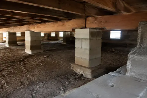 Timber floor framing visible inside a crawlspace, illustrative image