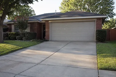 Broom-finished concrete driveway at a brick home, illustrative image