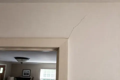 Visible crack in an interior drywall surface, illustrative image
