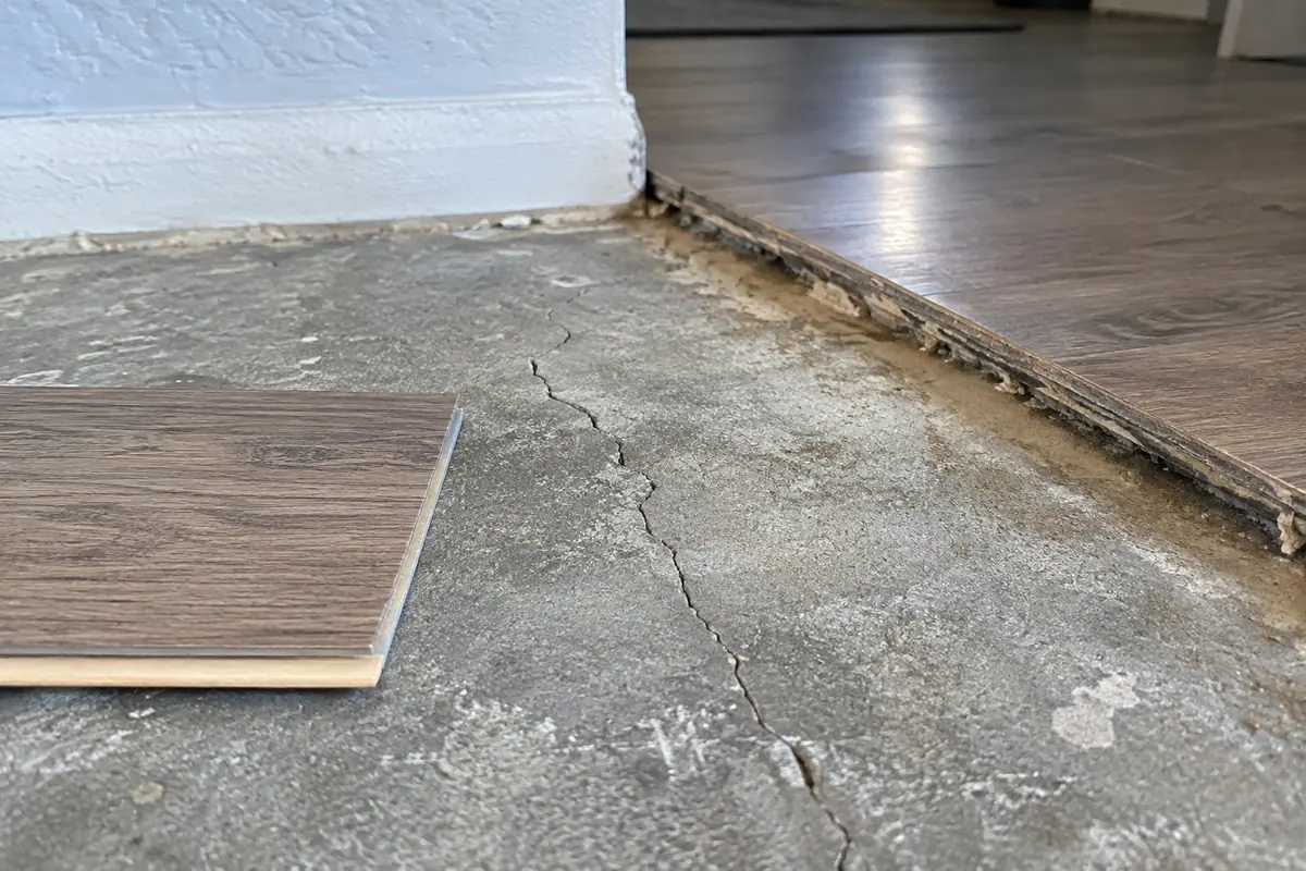 Fine crack in exposed concrete beside a flooring sample