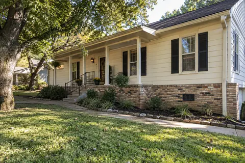 Raised cream-sided home with a brick perimeter skirt and crawlspace ventilation